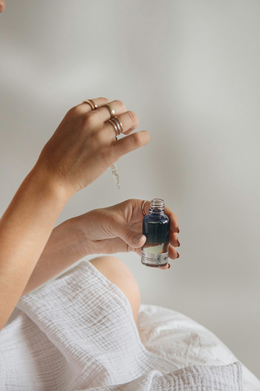 A hand holding a serum dropper bottle