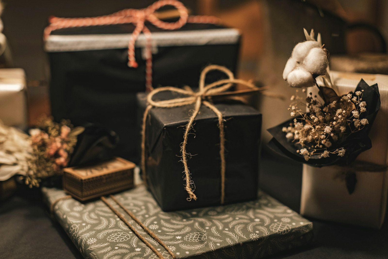 Black gift boxes tied with twine on patterned paper