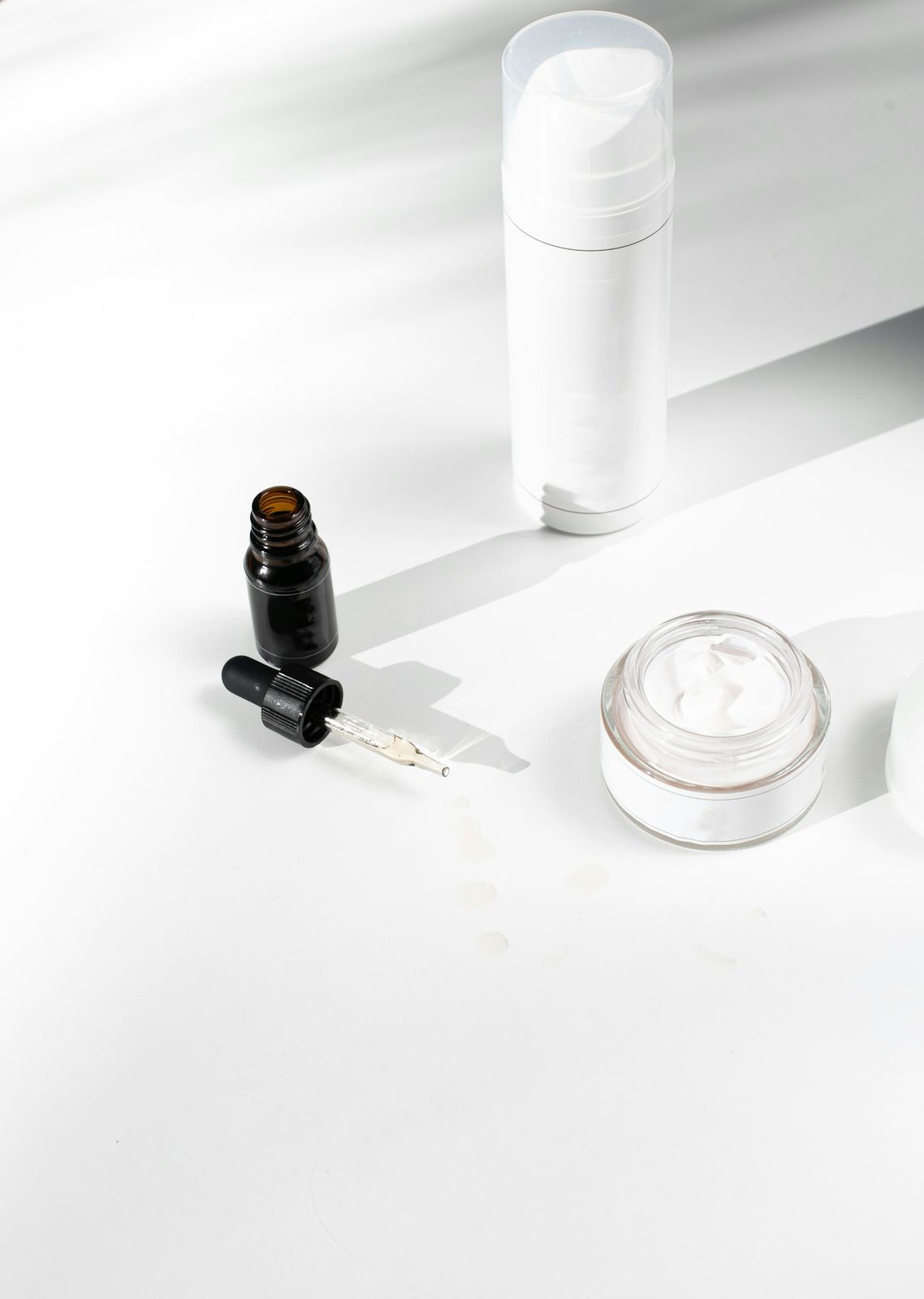 Unbranded skincare bottles and a jar in soft light
